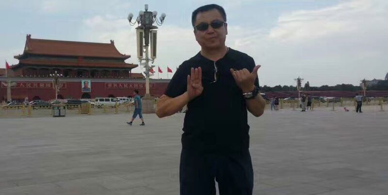 新公民运动成员张宝成在天安门广场手比出“六”和“四”手势的照片。(张宝成提供)