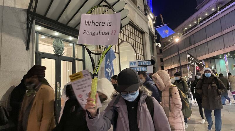 有游行人士举起网球拍，展示写上“彭帅在哪里？”(Where is Peng Shuai?)字句的标语，表达对中共噤声的不满。(吕熙摄)