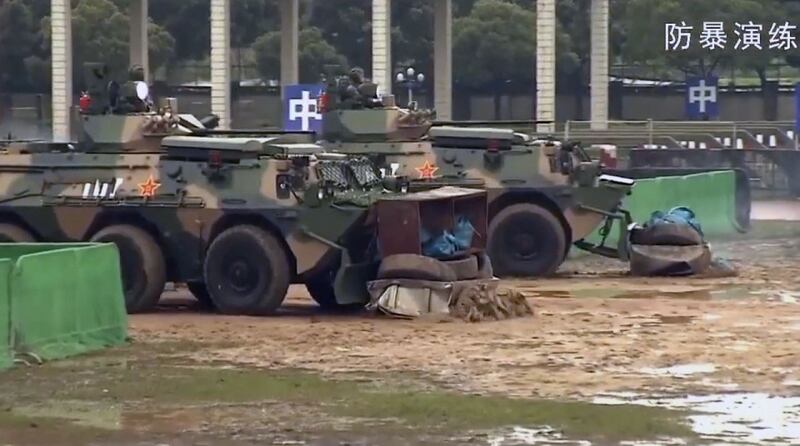 驻港解放军发宣传片中,有关防暴演练的画面,看到解放军模拟出动装甲车驱赶“示威者”,并将他们拘捕。(驻港部队宣传片截图)