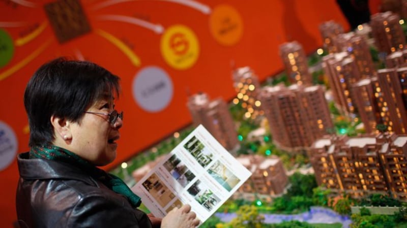 一名妇女正在观看上海的一场房地产展览(美联社)