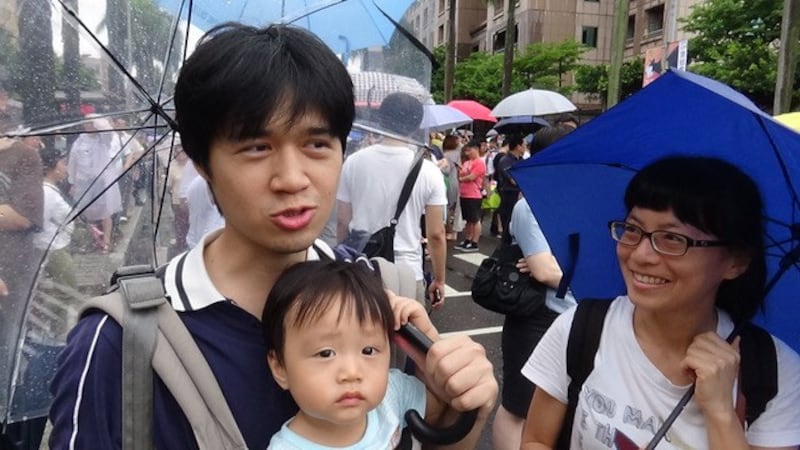 萧先生一家三口上街反红色媒体。(记者夏小华摄)