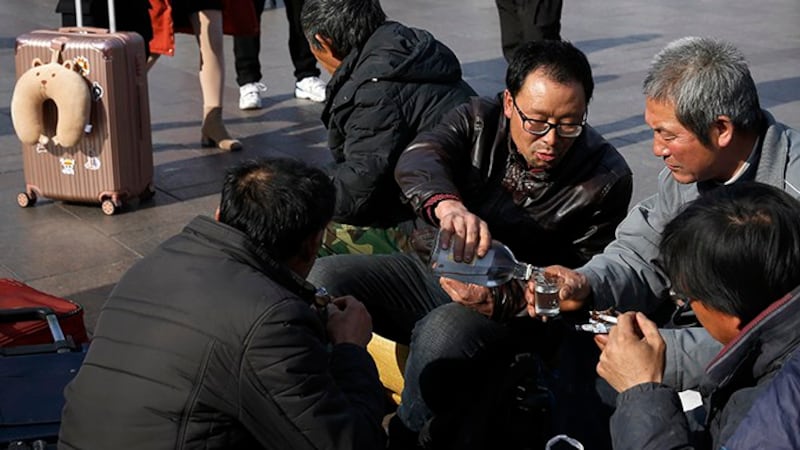 资料图片:2019年1月26日在北京站外等车的几名农民工(美联社)