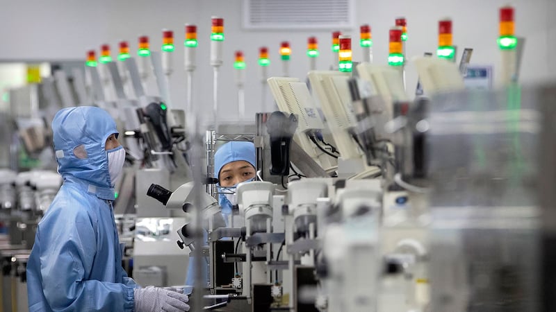 2020年5月14日,佩戴保护设备的员工在北京记者的政府组织游览期间在瑞萨电子的半导体生产设施中工作。(美联社)