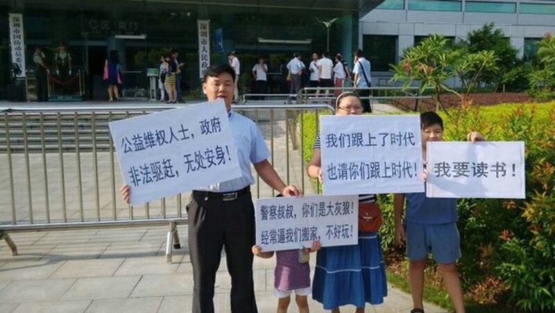 深圳春风劳动争议服务部负责人张治儒(左)被捕前带领家人在街头抗议(Public Domain)