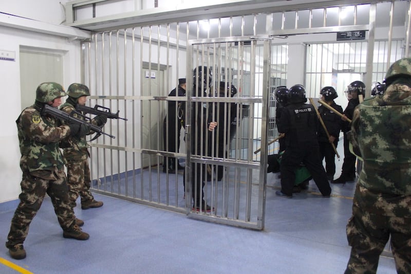 也有照片显示多名身穿迷彩服的武装人员,以突击步枪指向被黑色布袋蒙头的被扣押者。 (郑国恩推特截图)