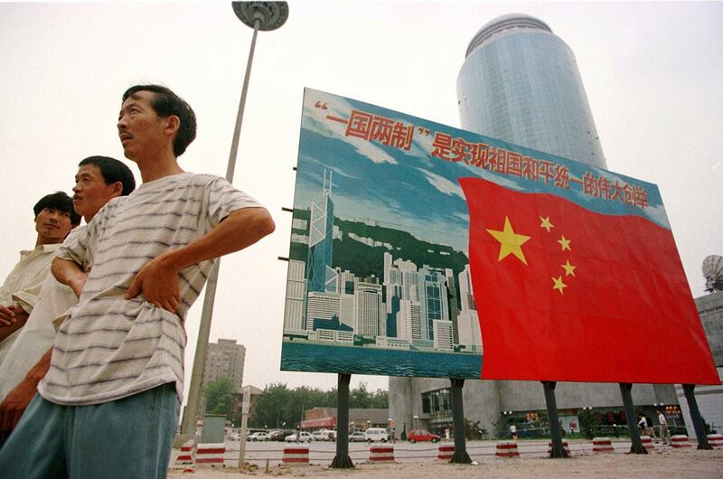 1997年7月16日，北京街头展示的香港天际线与中国国旗以及"一国两制"宣传口号。（美联社）