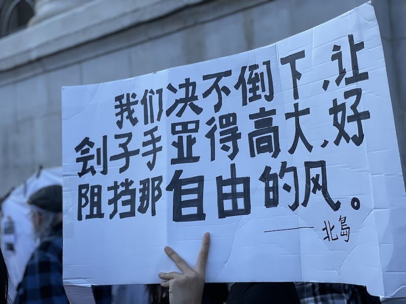 不少中国留学生手持鲜花和自制标语,默默加入集会。(吕熙拍摄)