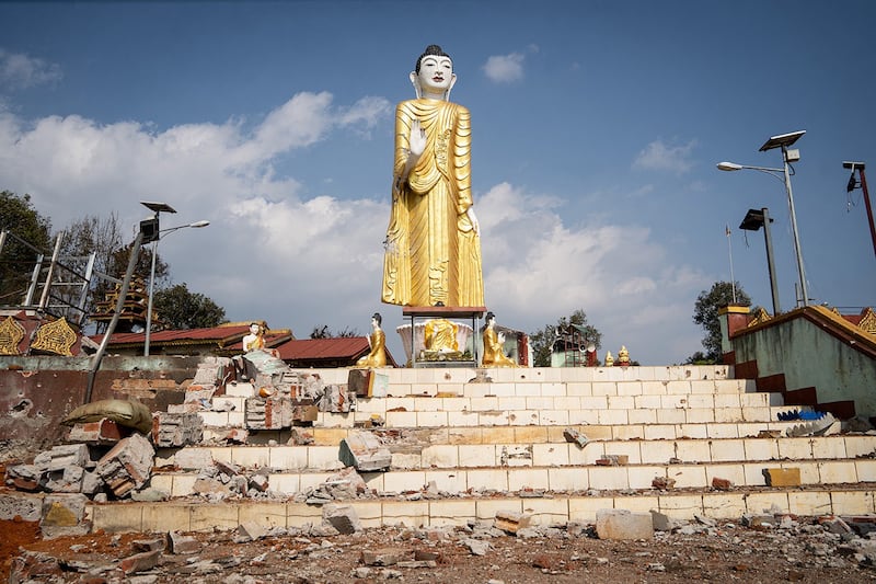 Debris lies scattered around a damaged statue of Buddha following fighting between Myanmar's military and the Kachin Independence Army in Nam Hpat Kar, Kutkai township in Myanmar's northern Shan State, Feb. 4, 2024. (AFP)