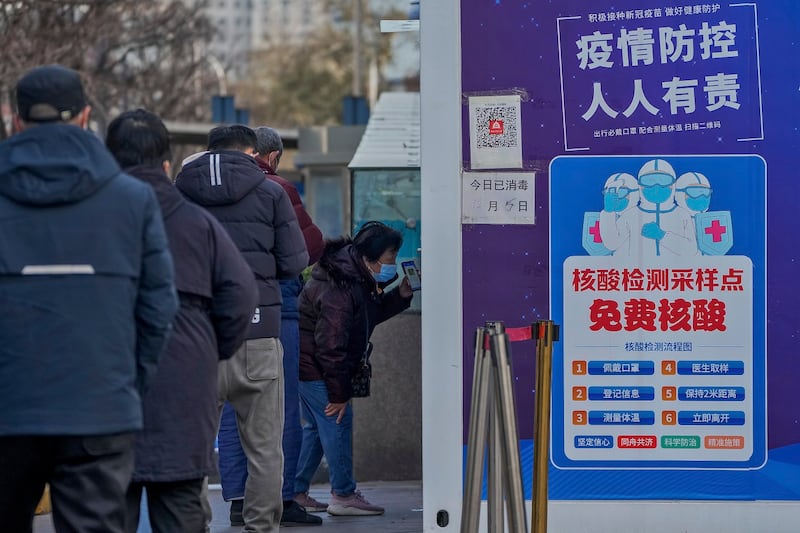 北京一名妇女2022年12月7日在准备检测核酸时出示健康码（美联社）