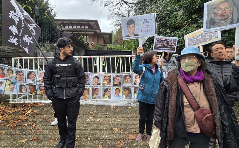 民众在中国驻温哥华领事馆前拉起了四十七人头像的横幅，为他们的无罪发出呐喊。中国领事馆特派出保全维安，保全人员并一直在现场拍照搜证。 (记者柳飞拍摄)