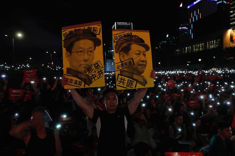 2019年6月26日，在香港集会上抗议者手持标牌“习近平与韩正画像”。（美联社）