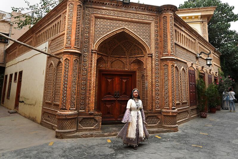 A Uyghur woman wears traditional clothing attire at the Old Kashgar tourist area in China's northwestern Xinjiang region, July 20, 2023.