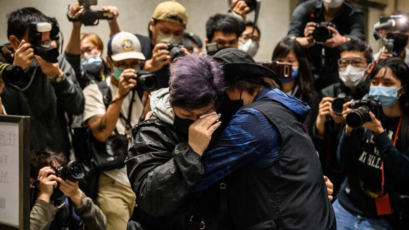 资料图片:2021 年 3 月 4 日,香港法院对 47 名被控“串谋颠覆国家政权罪”的民主活动人士,进行马拉松式的保释听证会结束时,支持者(中)在西九龙法院外被媒体成员包围时互相安慰。(法新社)