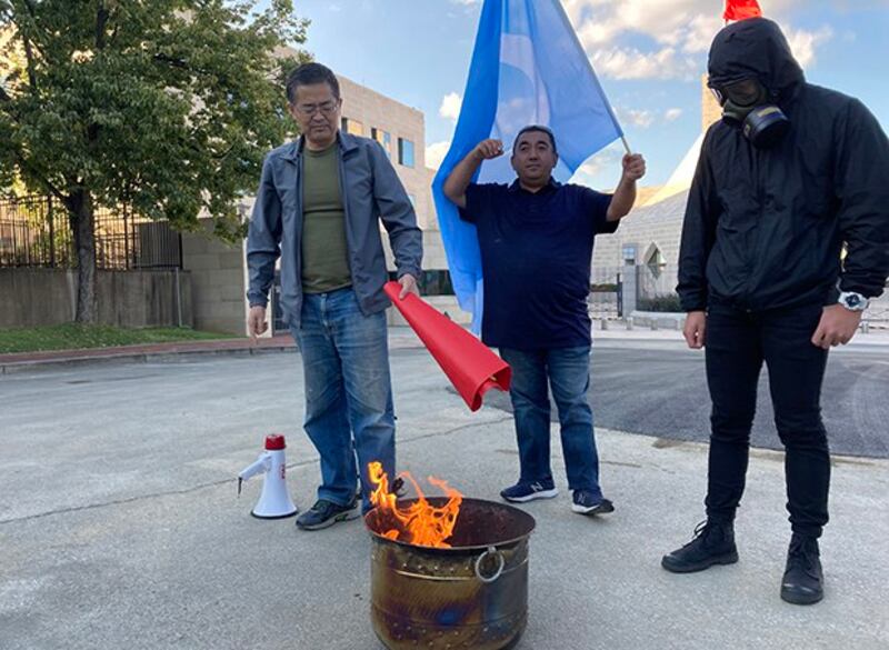 活动参加者将要焚烧的旗帜放向火盆(伊利夏提提供)
