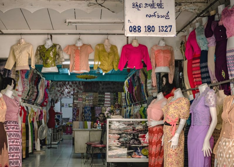 A Burmese-language sign hangs in a clothing store operated by Yi Win, a Myanmar man who immigrated shortly before the February 2021 coup, in his shop in the Phra Khanong section of Bangkok, March 13, 2024. (Wissarut Verasopon/Thai News Pix/BenarNews)