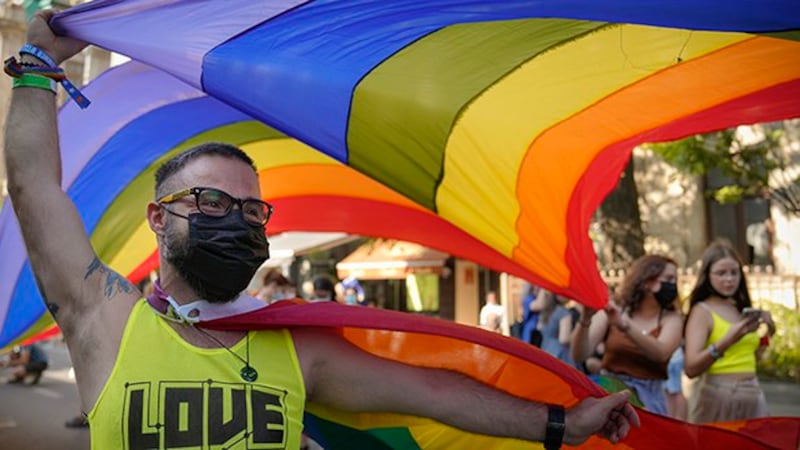 手举彩虹旗的游行民众(美联社图片)