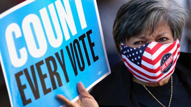 特朗普与拜登竞争激烈,计票工作耗时,一位选民举牌主张每张选票都应计入。(美联社)