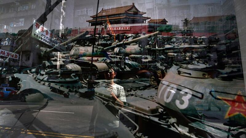 一名男子正在观看1989年6月4日摄于北京天安门广场的一张照片 (美联社资料图)