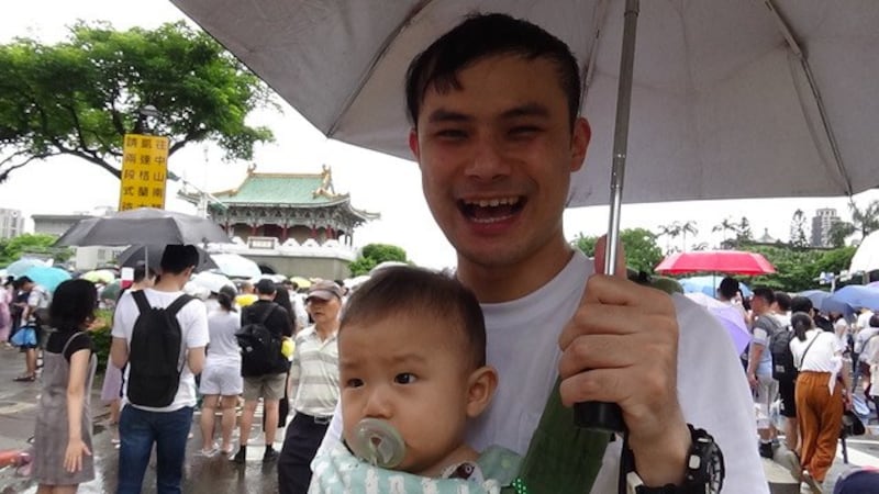 黄先生带妻小上街反红色媒体。(记者夏小华摄)