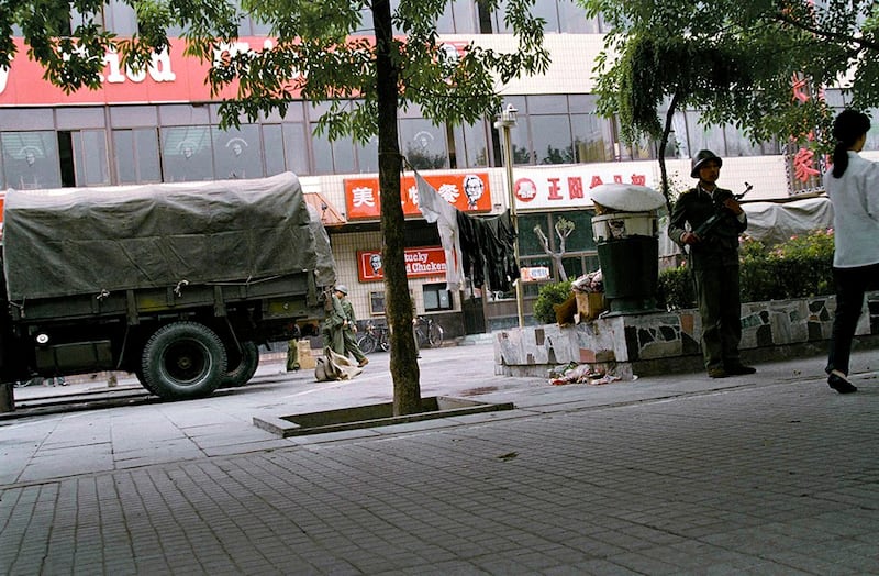 天安门镇压行动之后的六月十日，一名解放军士兵在当时北京唯一的西式快餐店前端枪警戒。(美联社资料图片)