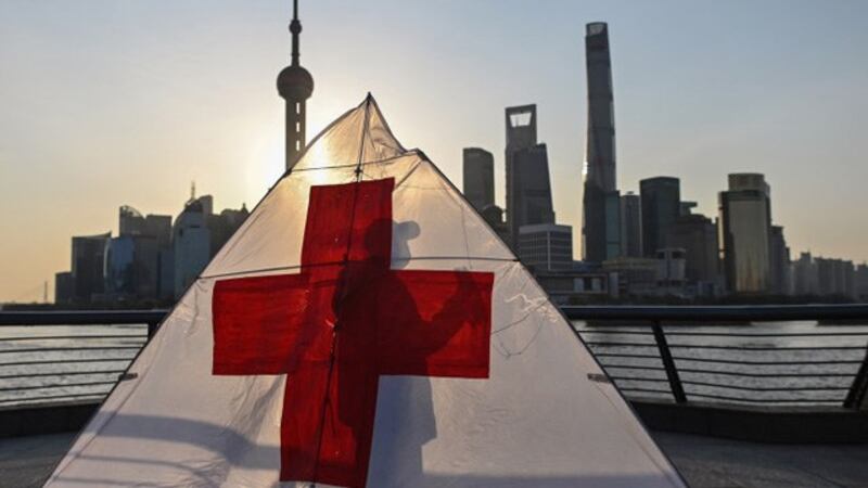 中国正极力甩脱 “病毒输出国”的形象,摇身一变成为救助者,向各国派遣医疗队,输出医疗物资,展开大外宣。图为上海外滩一名老翁的风筝。(法新社)