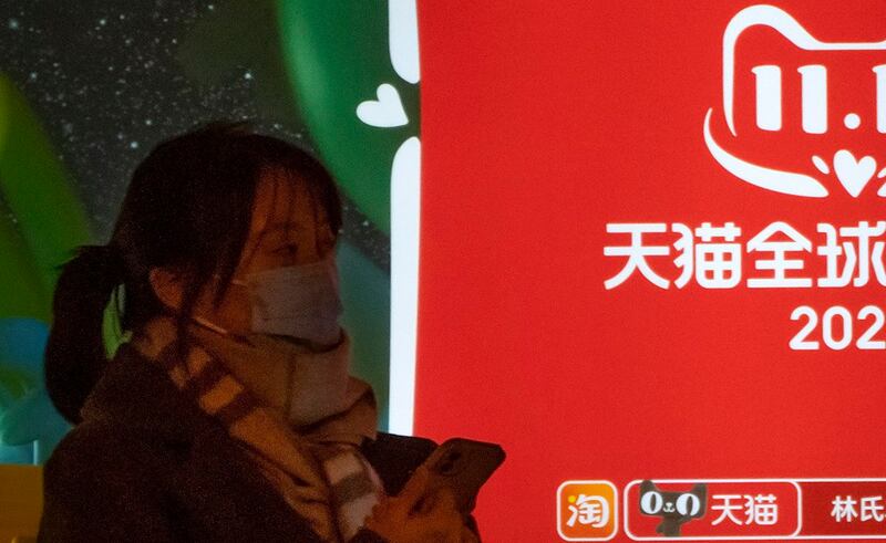 一名女子正在展示天猫广告的巴士站等待公交车(美联社图片)