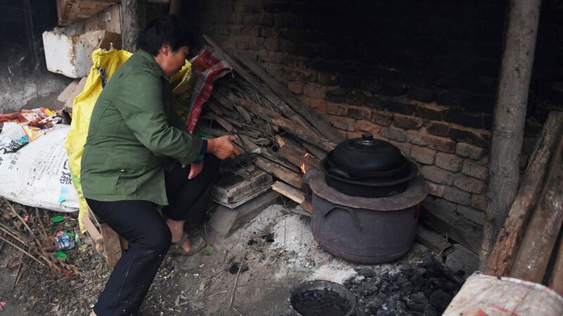 中国河南省贫困兰考县黄河附近的一个村庄,一位村民仍然使用老式的炊具。(法新社)