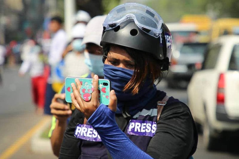 ၂၀၂၁ ခုနှစ် ဖေဖော်ဝါရီလ ၂၇ ရက်နေ့က ရန်ကုန်တိုင်း စမ်းချောင်းမြို့နယ်တွင် ပြုလုပ်သည့် လူထုဆန္ဒပြပွဲတစ်ခုအတွင်း သတင်းထောက်မသူဇာ တိုက်ရိုက်သတင်းထုတ်လွှင့်နေစဉ်။ (Photo courtesy of Thuzar)