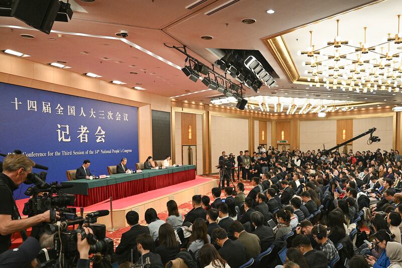 China’s Foreign Minister Wang Yi, podium, 2nd from left, speaks at a press conference during the ongoing National People’s Congress in Beijing on March 7, 2025.