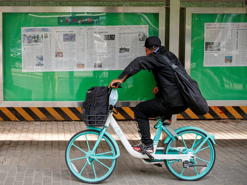 A man reads an issue of the Guangming Daily newspaper at a public display window in Beijing, China,  June 10, 2020.