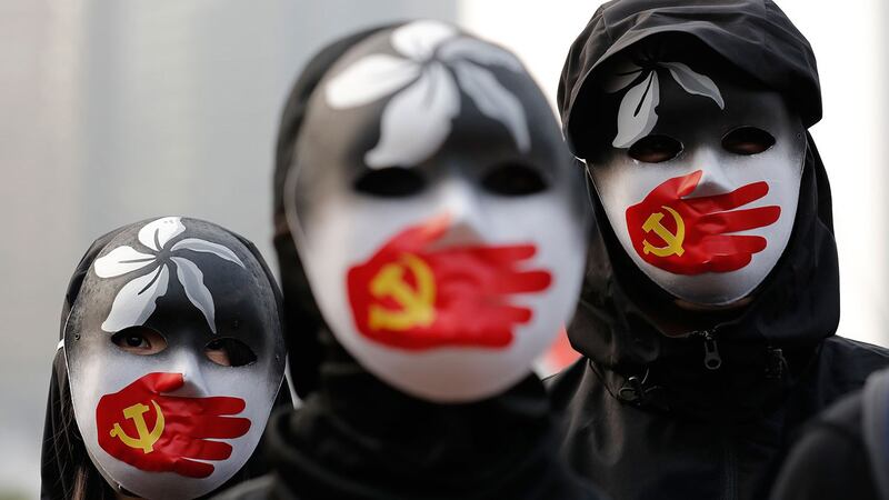 身着黑衣蒙面示威者在香港中心地带集会,声援香港人权自由。 (美联社)