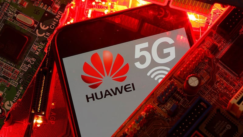 图为在PC主板上可以看到带有华为和5G网络徽标的智能手机。(路透社)